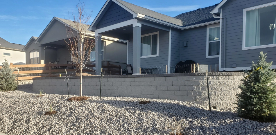 retaining wall of a blueish house with a dark grey roofing